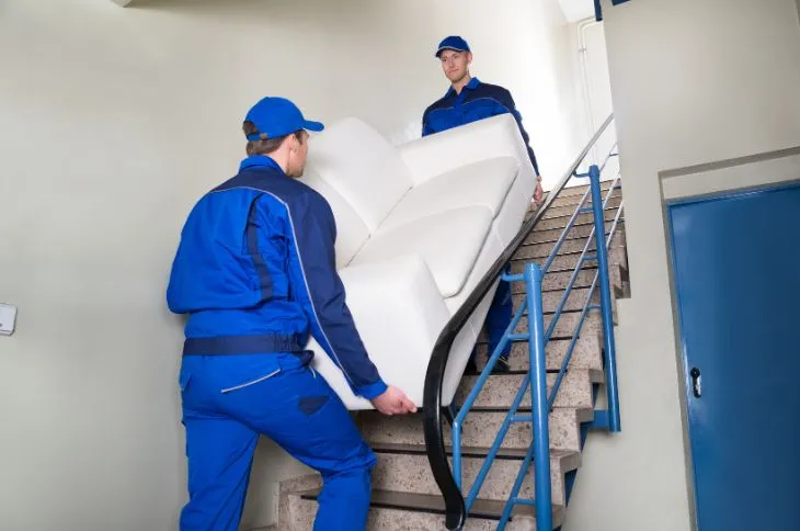 Möbelpacker tragen Sofa übers Treppenhaus